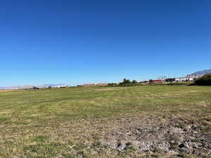 View of green lawn with a mountain view and a view of rural / pastoral area