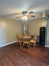 Dining area featuring dark wood finished floors, a textured ceiling, and a ceiling fan