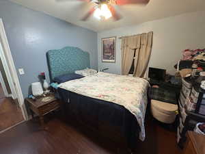 Bedroom with dark wood-type flooring and ceiling fan