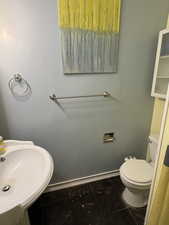 Bathroom featuring baseboards and toilet