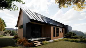 View of side of property featuring a standing seam roof, a lawn, a metal roof, and a deck with mountain view