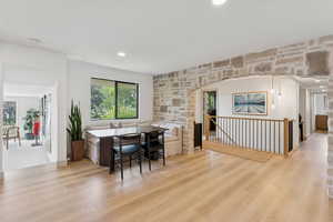 Dining space featuring light wood-style floors, arched walkways, and recessed lighting