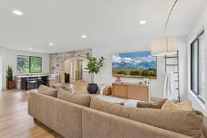 Living area with arched walkways, recessed lighting, and light wood-type flooring