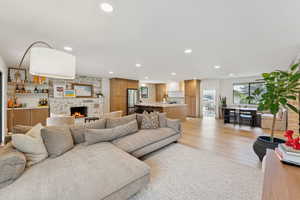 Living area featuring recessed lighting, light wood-type flooring, and a stone fireplace