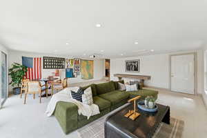 Carpeted living area featuring recessed lighting and baseboards