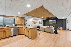 Kitchen featuring a peninsula, recessed lighting, a kitchen breakfast bar, wood ceiling, and stainless steel dishwasher