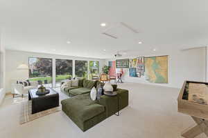Carpeted living room featuring recessed lighting and baseboards
