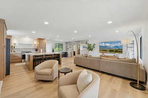 Living room featuring recessed lighting, arched walkways, and light wood-type flooring