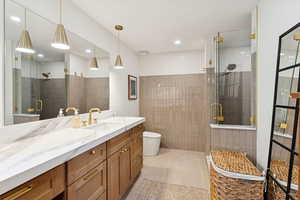 Bathroom featuring vanity, a stall shower, light tile patterned flooring, and recessed lighting