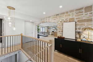 Corridor featuring recessed lighting, an upstairs landing, and arched walkways
