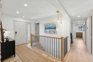 Hallway featuring an upstairs landing, recessed lighting, and light wood-style flooring