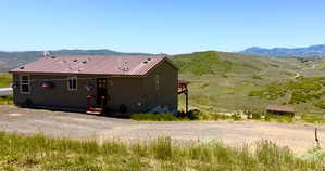 Single-story residence featuring a red metal roof and neutral siding