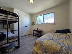 Bedroom featuring dark wood-style flooring, a closet, and a textured ceiling