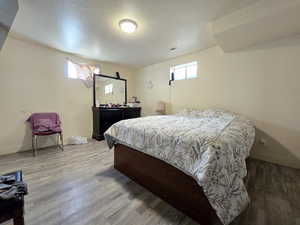 Bedroom with a textured ceiling and light wood-type flooring