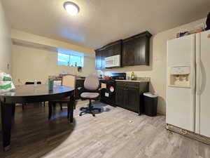 Office featuring light wood finished floors and a textured ceiling