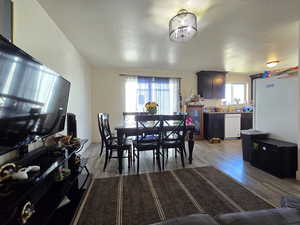 Dining space featuring light wood-style flooring and a textured ceiling