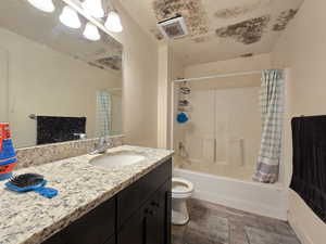 Bathroom featuring shower / bathtub combination with curtain and vanity