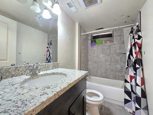 Bathroom with shower / bath combo with shower curtain, vanity, a textured ceiling, and light wood-style flooring