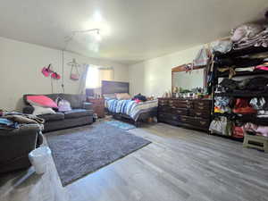 Bedroom with light wood-style flooring and a textured ceiling