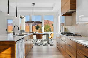 Kitchen with modern cabinets, brown cabinetry, and plenty of natural light