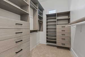 Walk in closet featuring light carpet