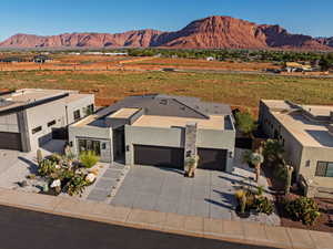 View of front of house with stucco siding, a mountain view, driveway, and an attached garage