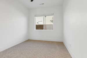 Unfurnished room featuring light carpet and a ceiling fan
