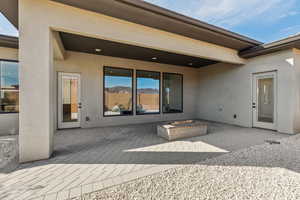 Rear view of house featuring stucco siding, a patio, and a fire pit