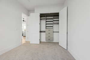Unfurnished bedroom with light colored carpet and a closet