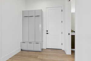 Mudroom with light wood finished floors and baseboards
