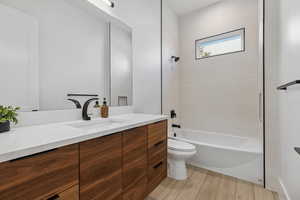 Bathroom featuring vanity, tub / shower combination, and light wood finished floors