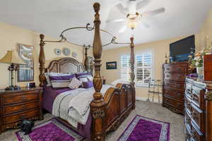 Carpeted bedroom featuring ceiling fan and baseboards