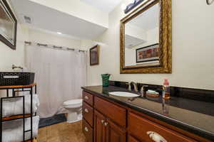 Bathroom with vanity, light tile patterned floors, and a shower with curtain