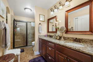Full bath with a shower stall and double vanity