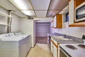 Washroom with light flooring and washer and dryer