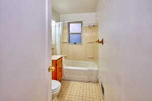Bathroom with shower / bath combo with shower curtain and vanity