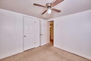 Unfurnished bedroom with carpet and a ceiling fan