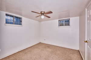 Unfurnished room featuring carpet floors, a textured ceiling, and ceiling fan