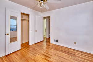 Unfurnished bedroom featuring light wood-style floors, a ceiling fan, and a closet