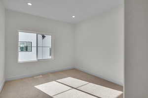 Room 2 with light colored carpet and recessed lighting