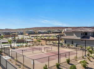 View of tennis court with a residential view