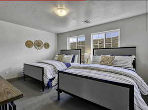Carpeted bedroom featuring a textured ceiling and baseboards