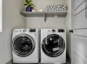 Laundry area featuring baseboards and washing machine and dryer