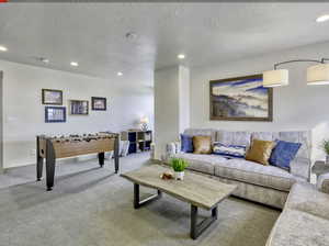 Living room featuring carpet flooring, recessed lighting, and a textured ceiling