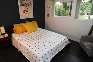 Bedroom featuring dark wood-style flooring and baseboards