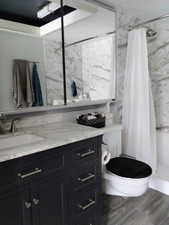 Bathroom with vanity, a shower stall, and wood finish floors