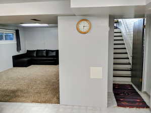 Living room featuring stairway and light carpet