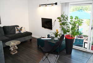 Living room featuring dark wood-type flooring and baseboards