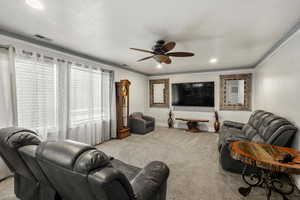 Living room with light carpet, ceiling fan, crown molding, recessed lighting, and a textured ceiling