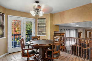 Dining room with a textured ceiling, ceiling fan, french doors, and light tile patterned floors